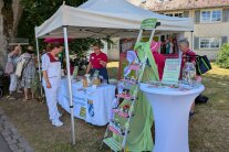 Personen stehen an einem Stand im Freien