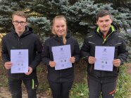 3 Personen stehen mit Urkunden nebeneinander