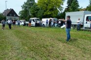Personen stehen auf einer Wiese